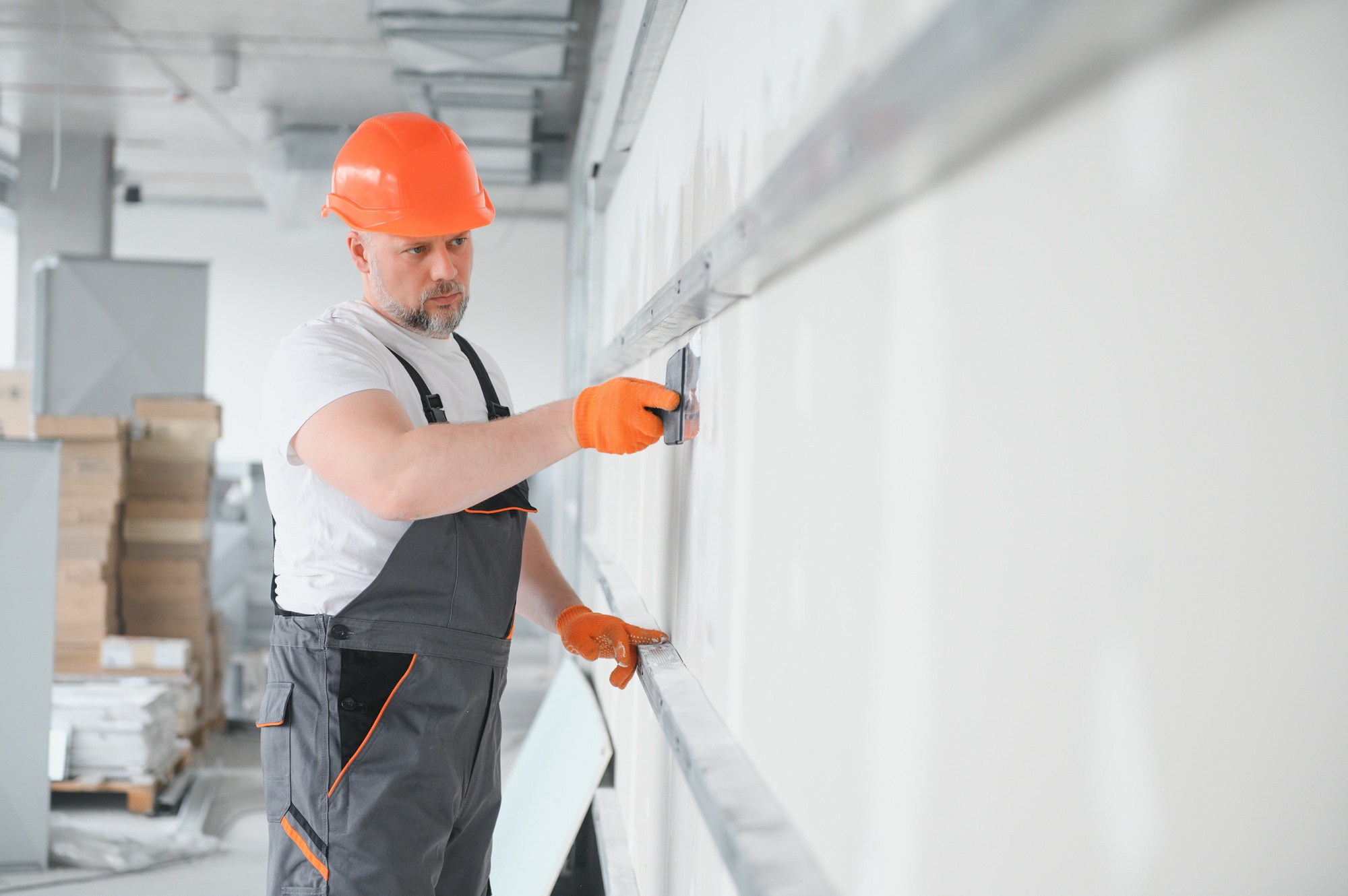 apartment interior construction - worker plastering gypsum board wall